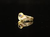 a close up of a gold ring with a blue stone