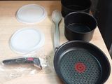 several pots and pans sitting on a table with a knife and spoon