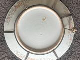a white plate with a gold rim sitting on a carpet