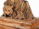a bronze statue of a woman sitting on a chair