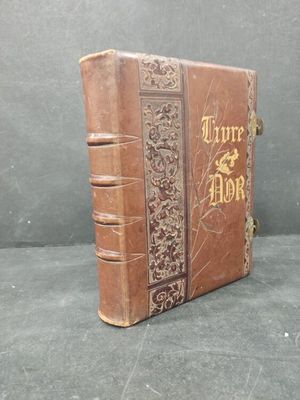 a brown book with gold writing on it sitting on a table