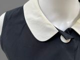 an image of a mannequin wearing a black dress with a white collar