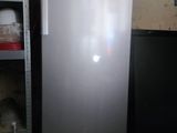 a silver refrigerator in a room with shelves and shelves