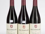 trois bouteilles de vin rouge posées sur une table blanche