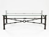 an iron and glass coffee table with a circular glass top