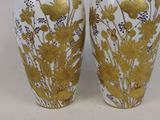 deux vases ornés de motifs dorés et blancs