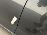 a person standing in front of a car with a sticker on it