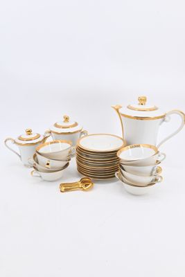 a white and gold tea set with cups and saucers