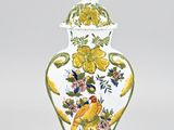 a white vase with yellow and blue flowers on it