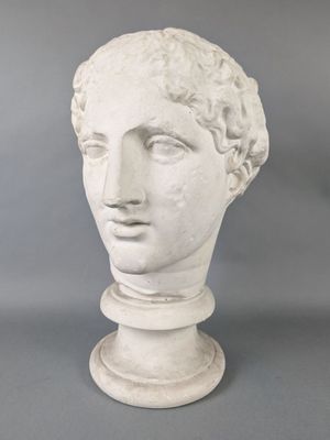 a close up of a statue of a man ' s head on a pedestal