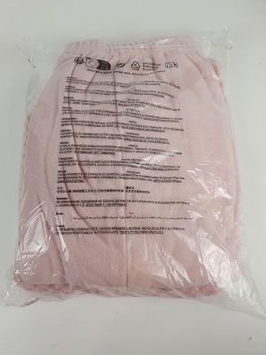 pink t - shirt in a plastic bag on a white surface