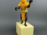 figurine of a man in a cheetah outfit standing on a cube