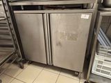 stainless steel double door refrigerators in a commercial kitchen with stainless steel shelves