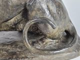 a silver statue of a cat with a curled tail