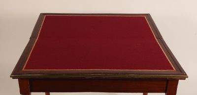 an old wooden table with a red cloth on top of it