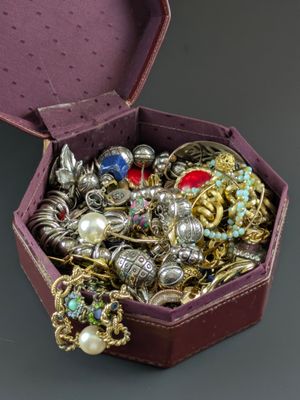 une boîte violette remplie de nombreux bijoux, posée sur une table
