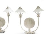 two silver metal table lamps with white shades on each of them