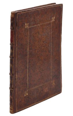 un vieux livre à la couverture brune posé sur une surface blanche