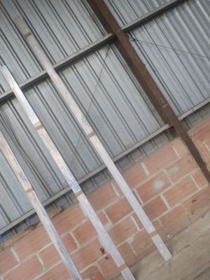 une borne d'incendie rouge posée devant un mur de briques