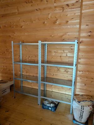 a room with wooden walls and a metal shelving in it