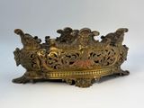 an old brass bowl with ornate designs on it on a white surface