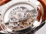 a close up of a watch with a brown leather strap