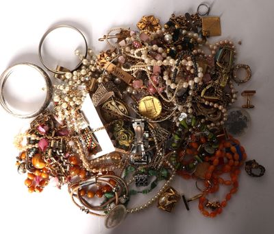 a pile of assorted jewelry on a white surface