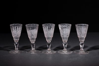 six empty wine glasses lined up on a black surface