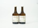 deux bouteilles de vin posées l'une à côté de l'autre sur une surface blanche