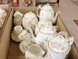 a box full of teapots and cups sitting on a table