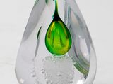 a glass vase with a green and white flower inside of it