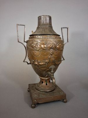 a silver vase on a stand on a white background