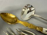a lot of silver spoons and forks on the table