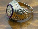 silver ring with a purple stone on a wooden surface