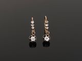 une paire de boucles d'oreilles en diamant sur une surface noire