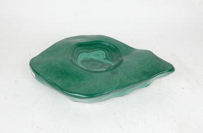 a green glass ashtray on a white background