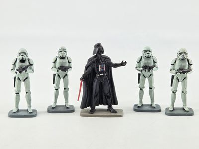 Des figurines de Star Wars sont alignées sur une surface blanche