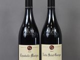two bottles of wine sitting on top of a table next to each other