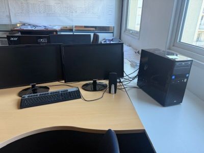 a desk with two computer monitors and a keyboard on it