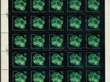 the stamp shows a lot of green clovers on a black background