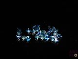 some very pretty blue diamonds on a black surface in the dark