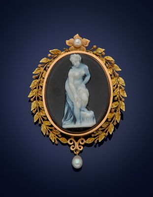 une image représentant une broche sur laquelle figure une femme tenant une perle