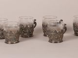 four glasses with handles and handles are lined up on a table