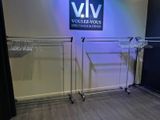 a rack of clothes in a room with a sign on the wall