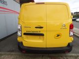 the back of a yellow van parked in front of a building