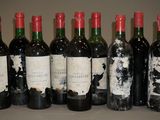 six bouteilles de vin sont alignées sur une table