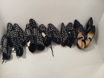 Plusieurs paires de chaussures noires et blanches sont alignées en rangée