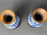 pair of blue and white vases with gold rims on a gray surface