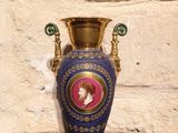 a blue vase with a picture of a woman on it
