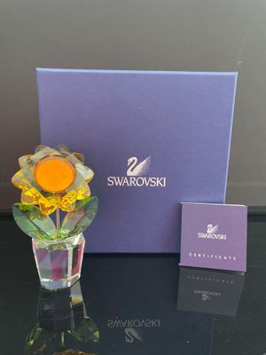 un vase en verre avec une fleur à l'intérieur sur une table